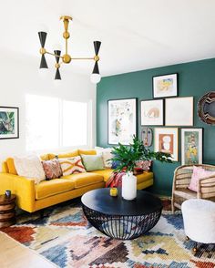 a living room with yellow couches and pictures on the wall above it, along with other furniture