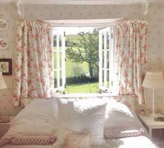 a bed sitting under a window in a bedroom