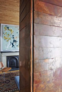 a room with wood paneling and a painting on the wall next to a chair