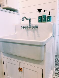 a white sink sitting next to a cabinet in a bathroom