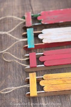 popsicle sticks are lined up on a wooden table with string attached to the ends