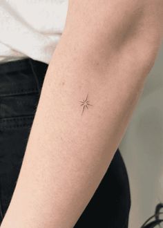 a person with a small star tattoo on their left arm and the other arm behind her