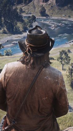 a man with a hat on looking out over a valley