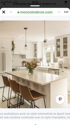 a kitchen with white cabinets and an island in the middle, surrounded by bar stools