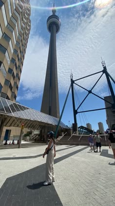 a woman standing in front of a tall building with a sky scraper behind her