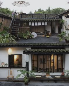 an outside view of a house with plants on the roof and stairs leading up to it