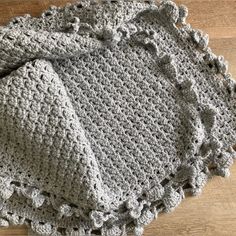 two crocheted afghans sitting on top of a wooden floor