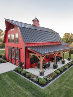 a large red barn with a covered patio and dining area in the middle of it