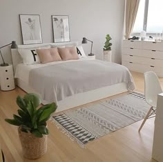 an image of a bedroom with minimalist bedding and decor on the bottom right hand corner