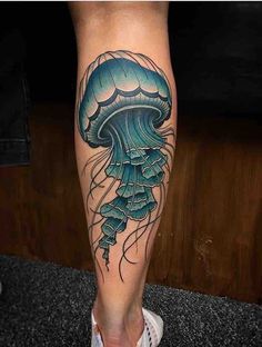 a person with a tattoo on their leg that has a jellyfish in the water