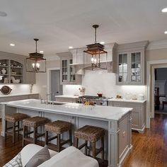 an image of a kitchen with white counter tops and gray cabinets in the center island