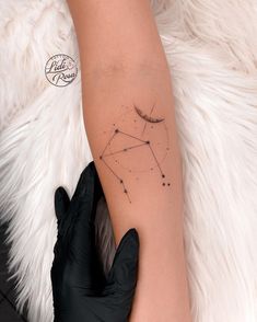 a woman's arm with a star tattoo on it and a black glove holding the arm