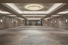 an empty ballroom with chandelier and carpeted walls in the center is shown