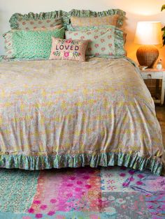 a bed with colorful bedspread and pillows on it