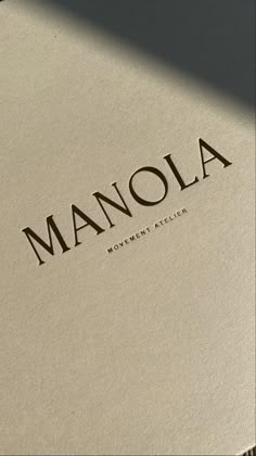 the word manola is placed on top of a book