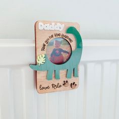 a wooden photo frame with an image of a dinosaur on it and the words daddy