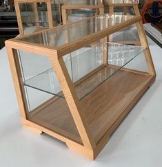 a wooden display case with glass shelves on top