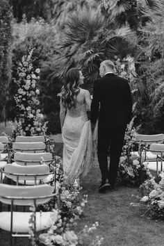 a bride and groom walking down the aisle at their wedding ceremony in black and white