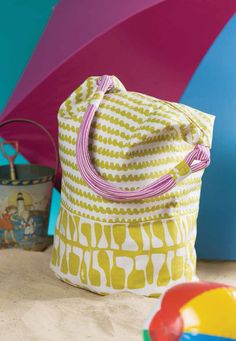 a yellow and white bag sitting on top of a floor next to a beach ball