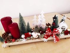 a wooden tray filled with christmas decorations and candles