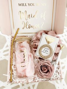 a pink box with gold foil lettering and flowers in it that says, will you be my maid of honor?