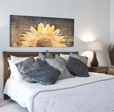 a bedroom with a large sunflower painting on the wall above the bed and two lamps