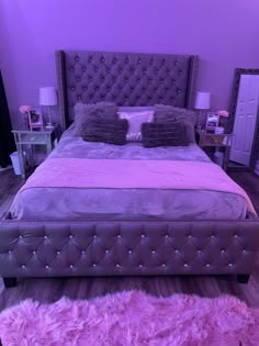 a bed that has some pillows on it in a room with purple walls and carpet