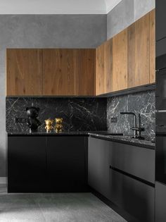 a kitchen with marble counter tops and wooden cabinets in black, grey and white colors