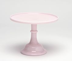 a pink cake plate sitting on top of a white table