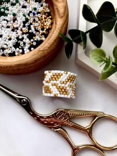 a pair of scissors sitting on top of a table next to beads