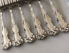 a set of six silverplated forks sitting next to each other on a table