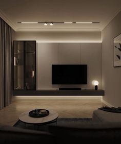 a modern living room with white walls and black furniture, along with a large flat screen tv on the wall