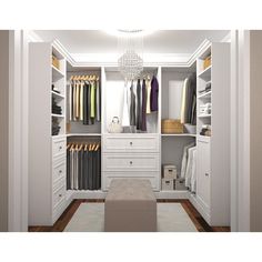 a walk in closet with white cabinets and drawers, chandelier hanging from the ceiling