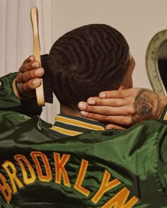 a man with dreadlocks is combing his hair in front of a mirror