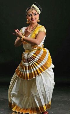 a woman in a yellow and white dress is dancing with her hands out to the side