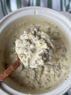 a spoon full of mashed potatoes in a white bowl