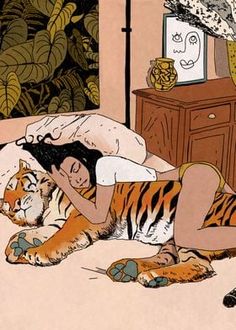 a woman laying on top of a bed next to a tiger