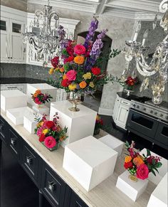 there are many vases with flowers in them on the counter top next to each other