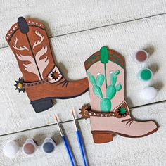 the cowboy boots are next to paint and brushes