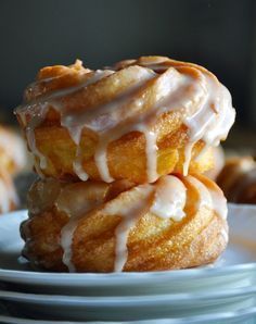 a stack of donuts with icing on them sitting on top of white plates