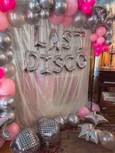 the balloon arch is decorated with silver, pink and silver balloons that spell out just disco