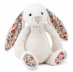 a white stuffed rabbit with floral designs on it's ears and legs, sitting in front of a white background