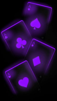 three glowing purple playing cards in the dark