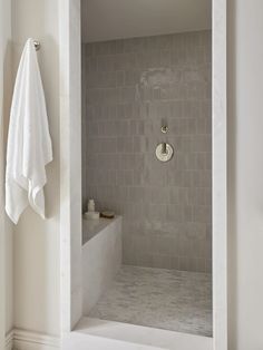 a bath room with a shower and a towel hanging on the wall next to it