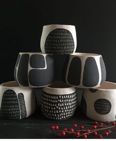 several black and white vases sitting next to each other on top of a table