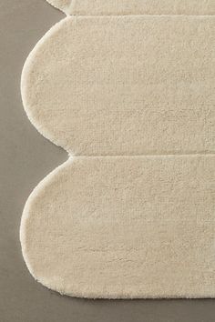 three white rugs on top of each other in the shape of an oval, rectangle shaped object