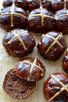 hot cross buns on a baking sheet with one cut in half