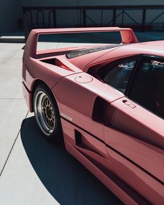 a pink sports car parked in front of a building