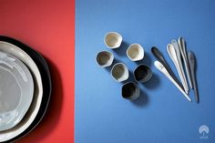 there are many spoons and bowls next to each other on the same color surface