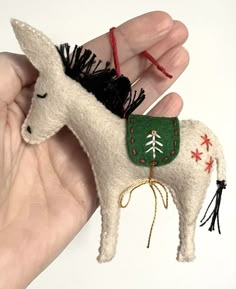 a hand holding a small white horse ornament